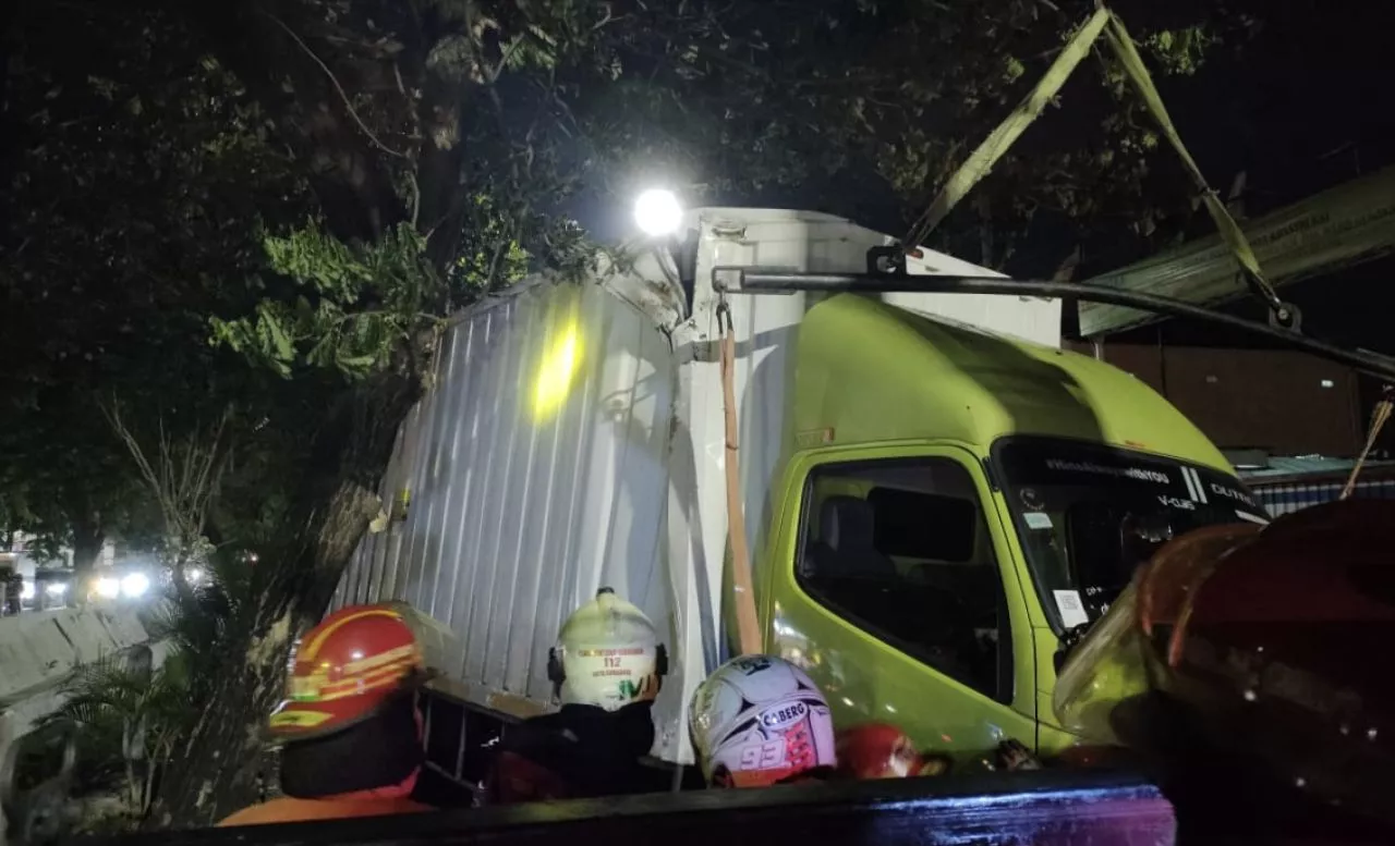 Sopir Ngantuk, Truk Boks Naik ke Trotoar dan Tersangkut Pohon