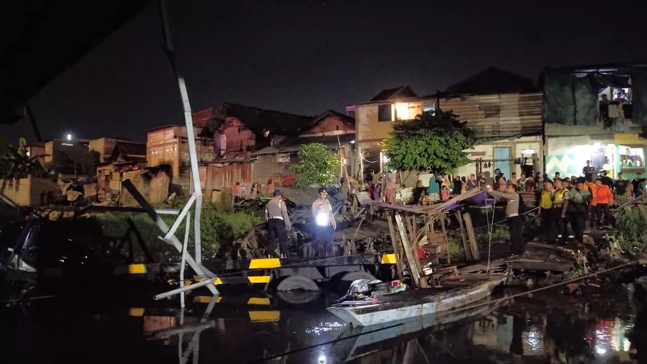 Jatuh dari Tol Dupak, Truk Trailer Tercebur Sungai dan Timpa Perahu Tambang