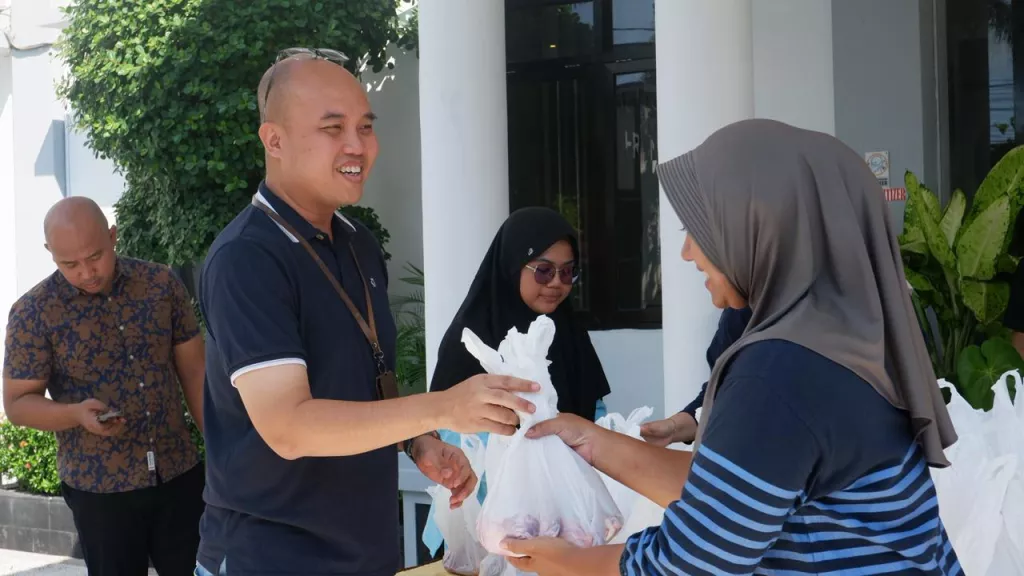 Kasi Pidsus Kejari Nganjuk saat bagikan paket daging kurban pada warga. (Dok. Kejari Nganjuk).