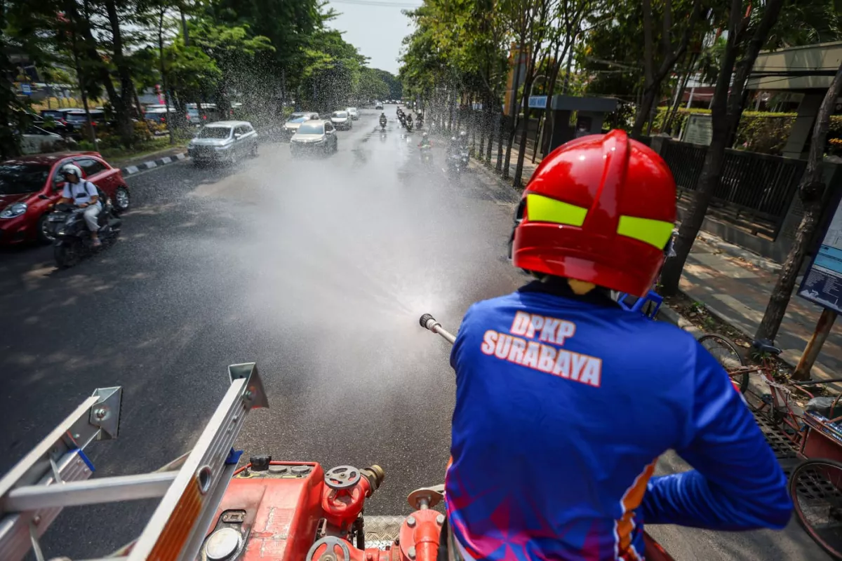 Momen Petugas Damkar Bahasi Jalan di Tengah Panasnya Surabaya