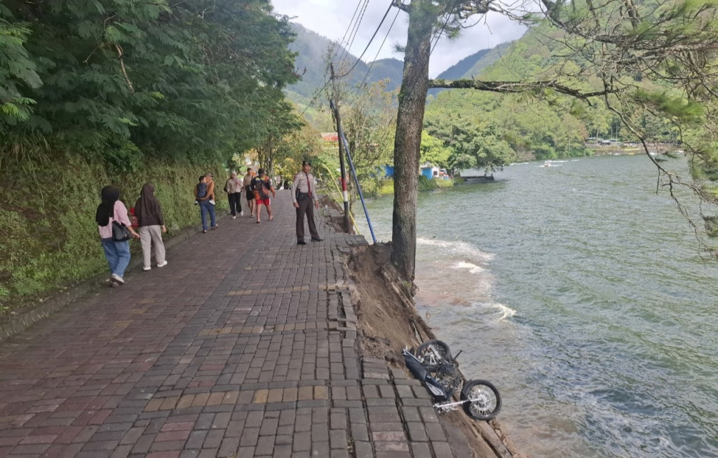 Lokasi amblas di Telaga Sarangan. Terlihat satu motor yang terguling dan hampir tercebur