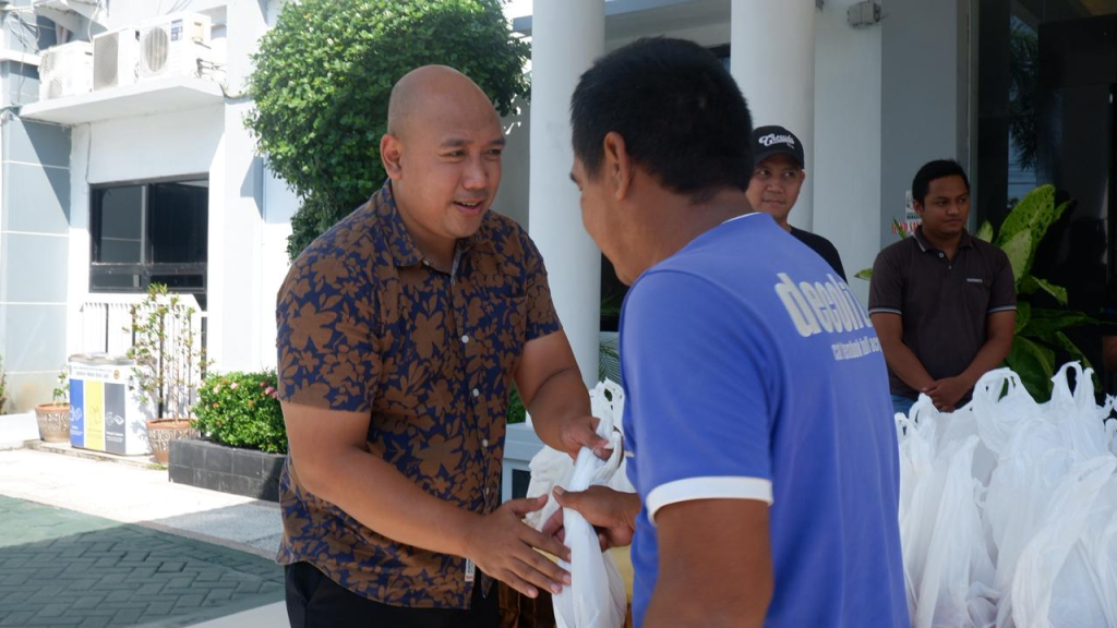 Kasi Intel Kejari Nganjuk saat bagikan paket daging kurban pada warga. (Dok. Kejari Nganjuk).