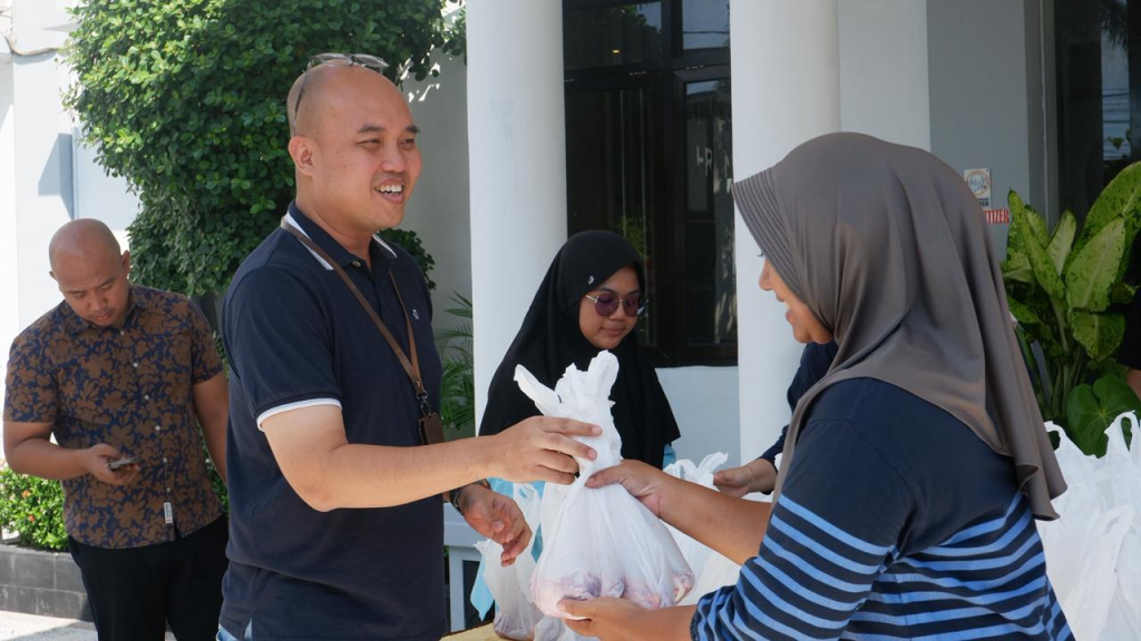Kasi Pidsus Kejari Nganjuk saat bagikan paket daging kurban pada warga. (Dok. Kejari Nganjuk).